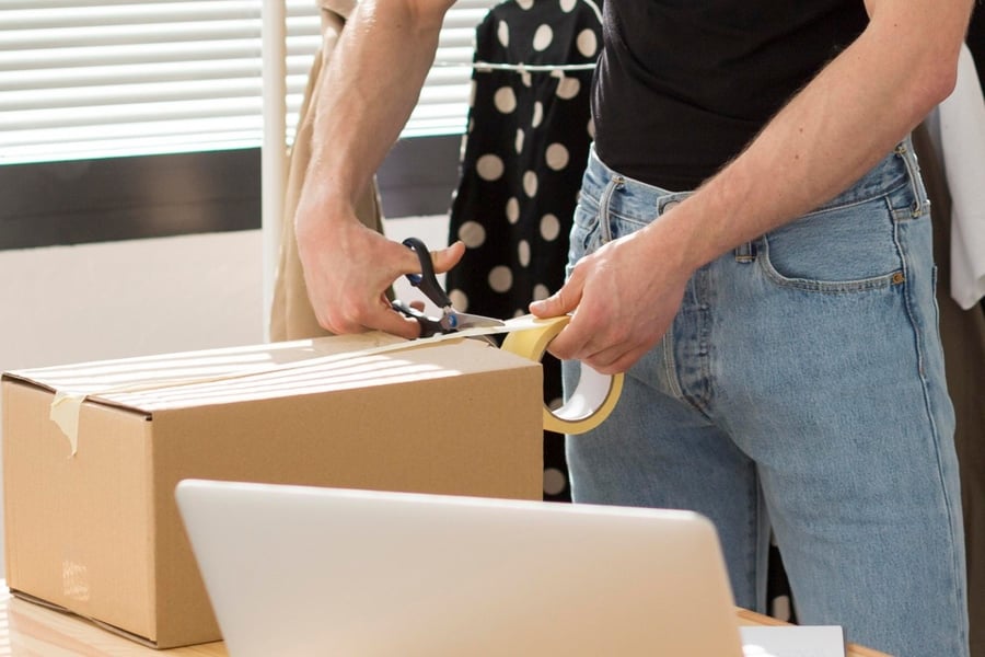 Person, die eine Rücksendung verpackt